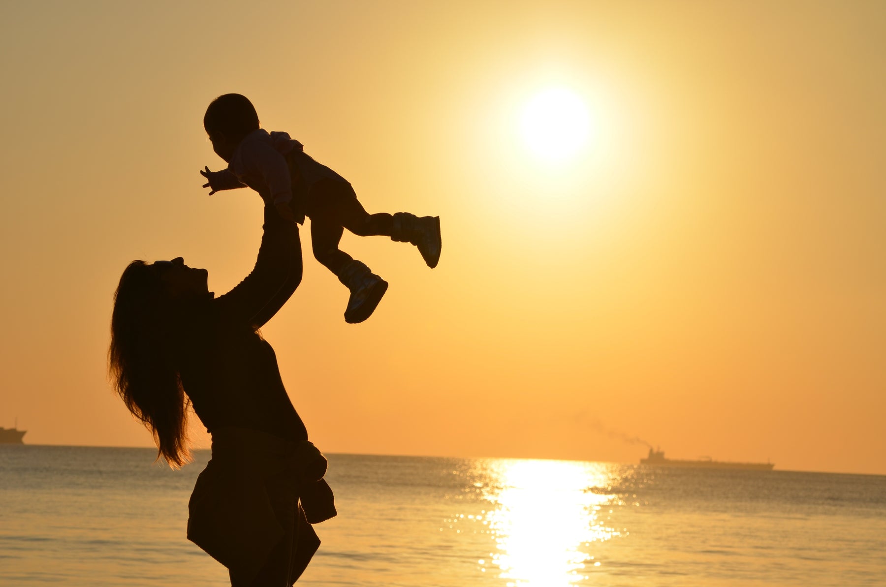 mother holding son during sunset on beach