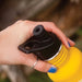 klean kanteen sport top black with yellow bottle held by light skinned adult hand