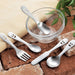 petit cutlery happy face baby cutlery small stainless steel cutlery on bricks and in a bowl
